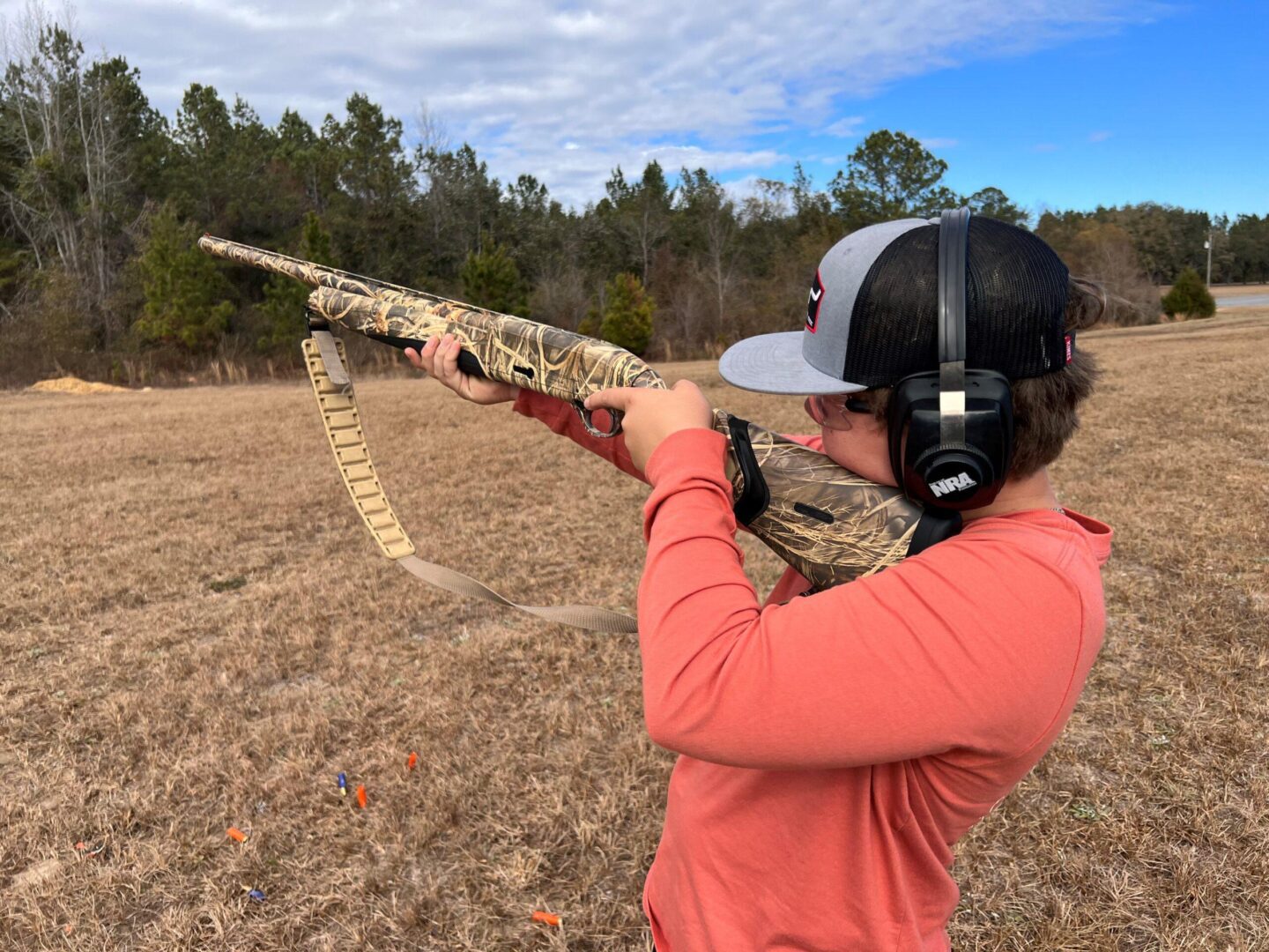 Person aiming camo shotgun wearing ear protection Person aiming camo shotgun wearing ear protection
