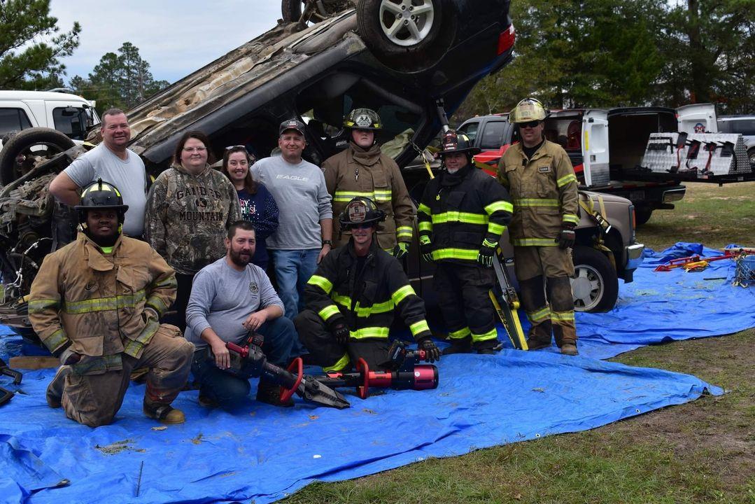 A group of people standing around an overturned truck.