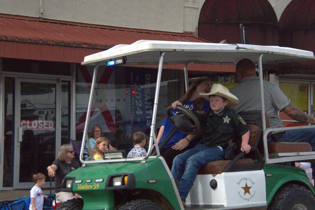 A group of people riding in the back of a golf cart.