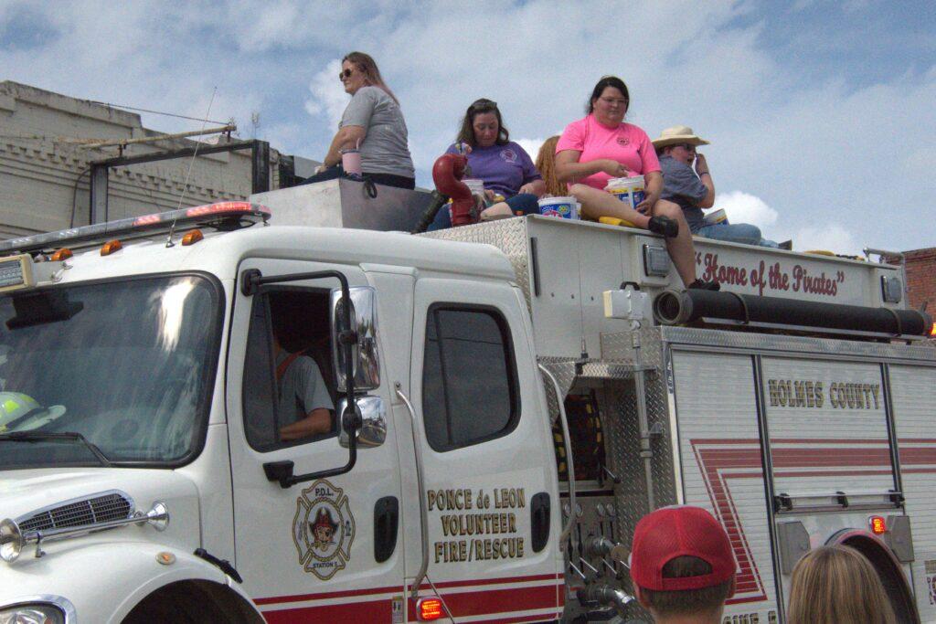 A group of people sitting on top of a fire truck.