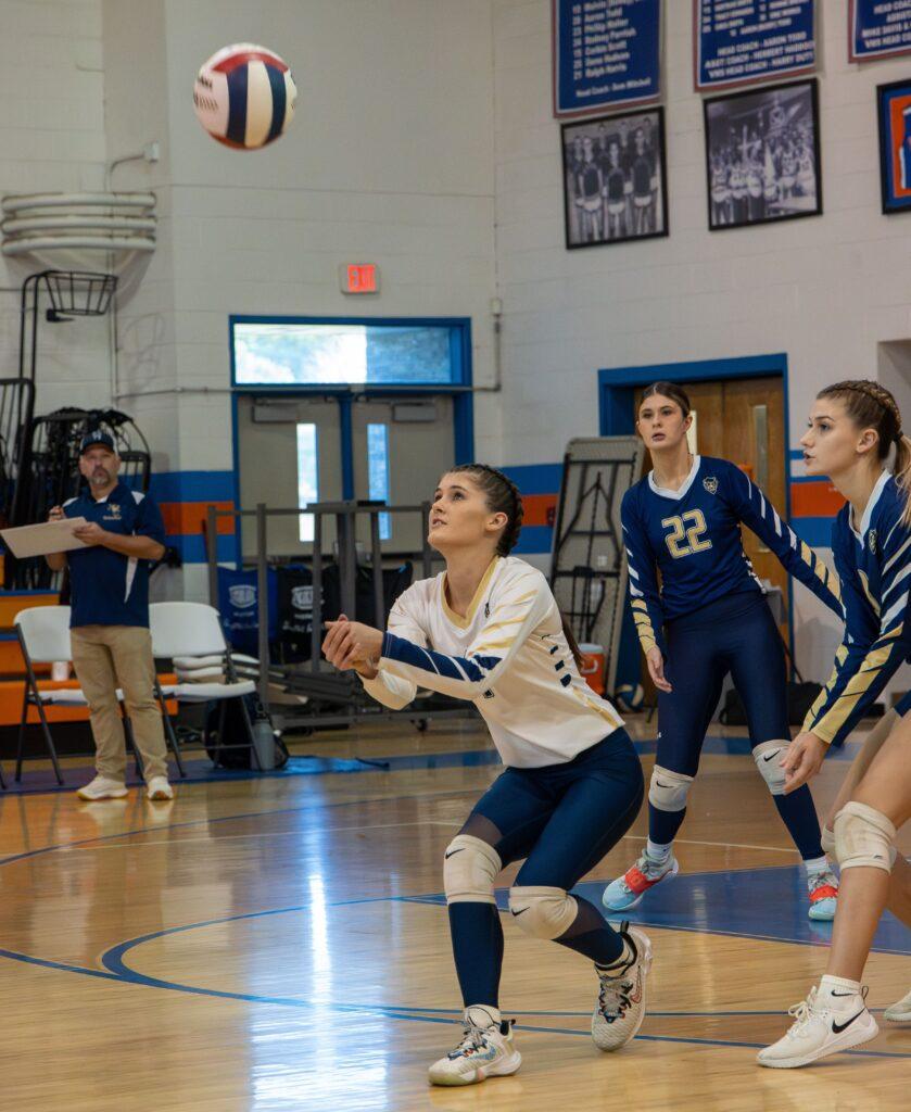 A group of people playing volleyball on a court.