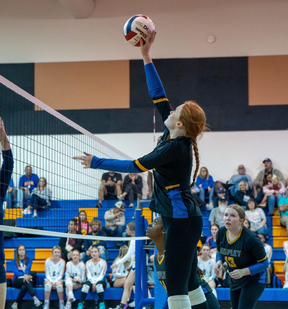 A person in black and blue volleyball uniform playing volley ball.
