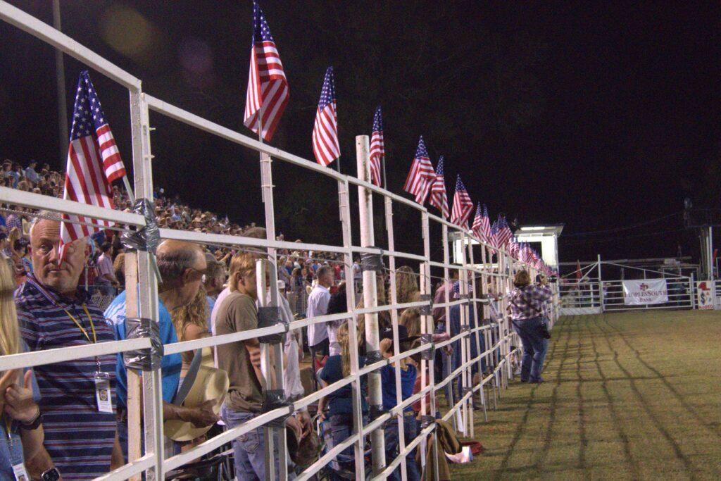 A crowd of people standing in front of a fence.