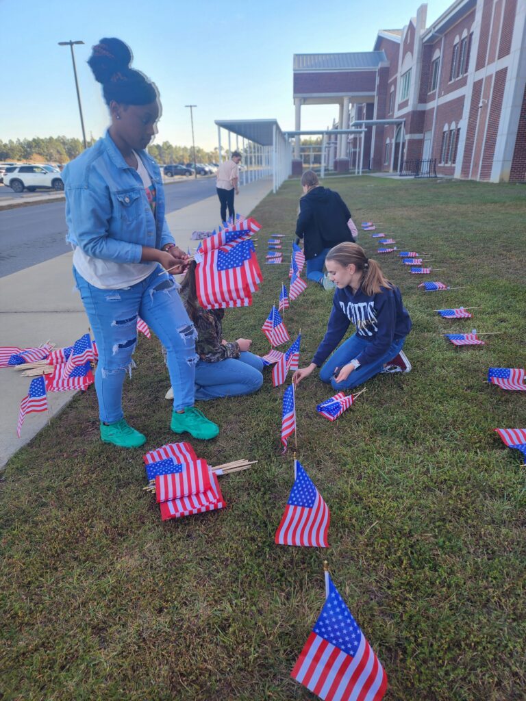 A group of people standing around some flags