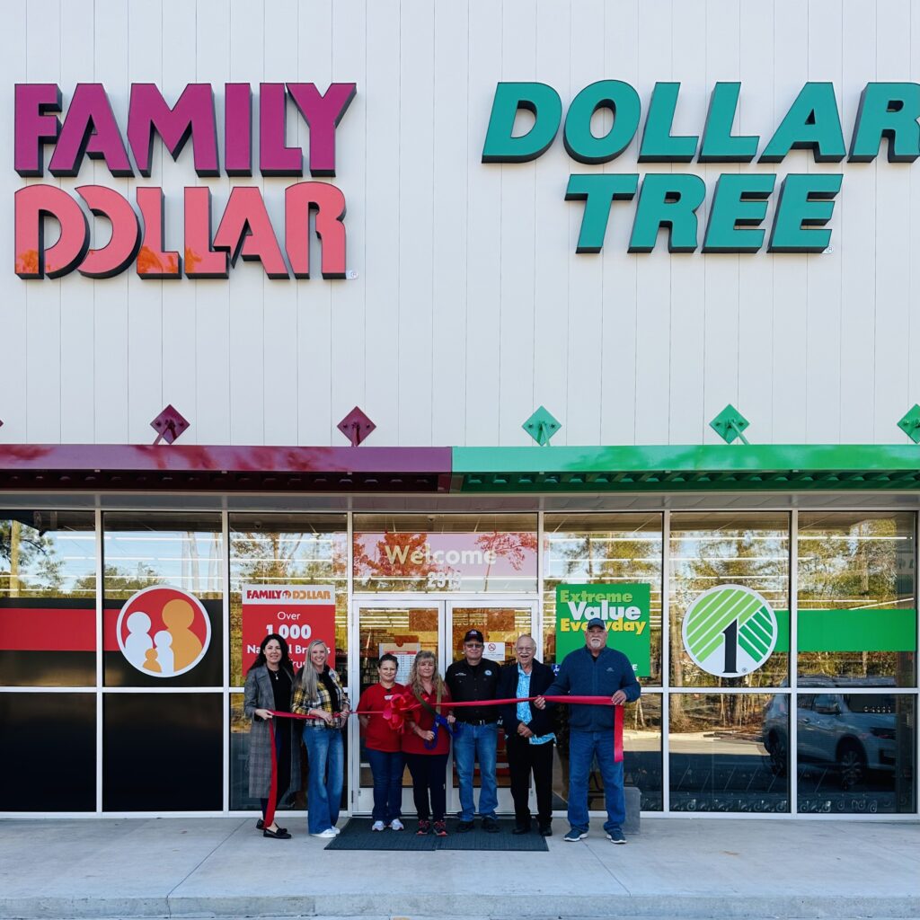 A family standing in front of the entrance to a dollar tree.