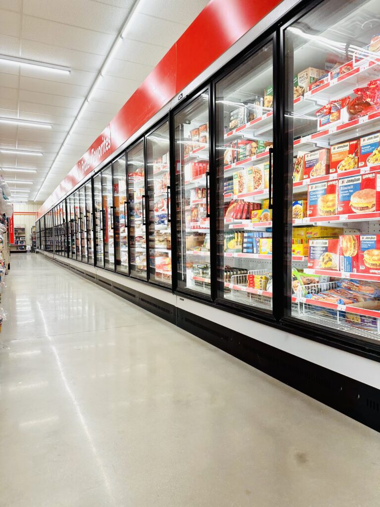 A store with many refrigerators and shelves of food.