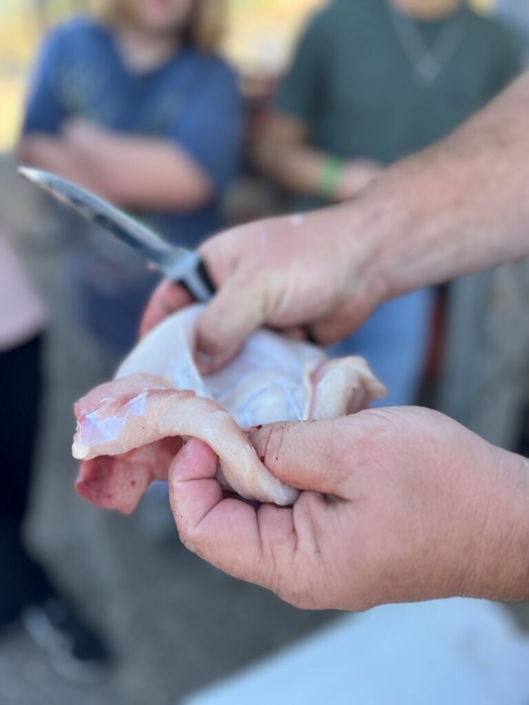 A person holding a piece of meat in their hands.