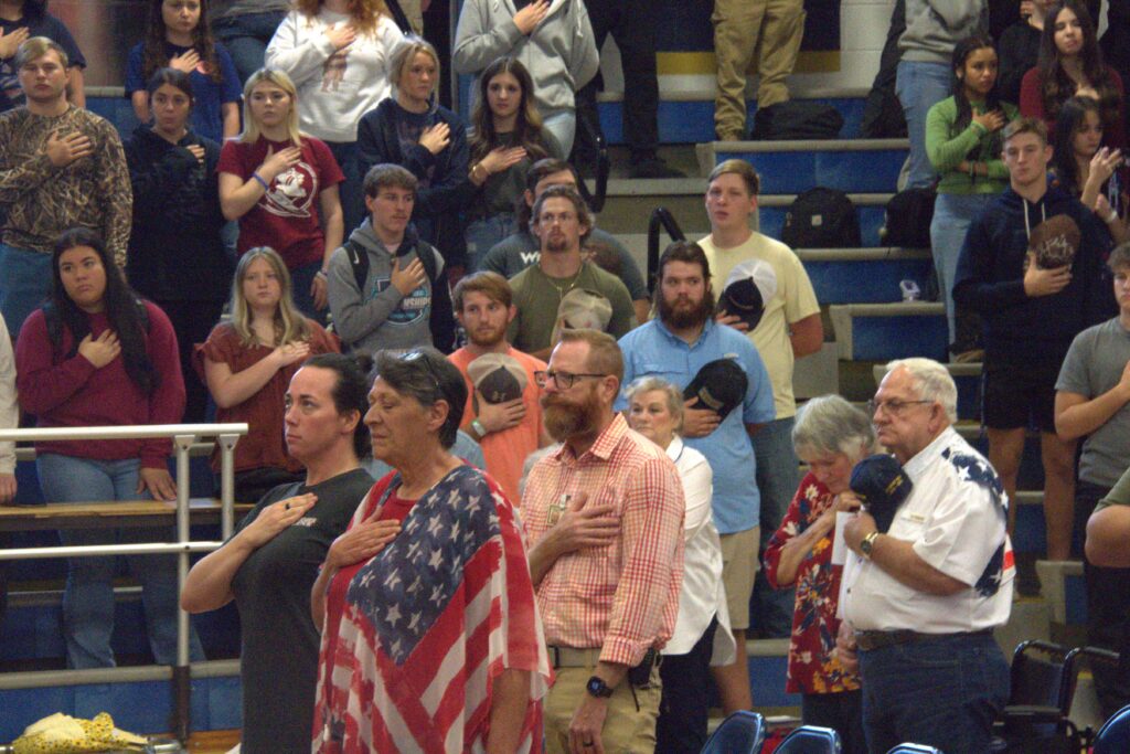 A crowd of people standing in front of an audience.