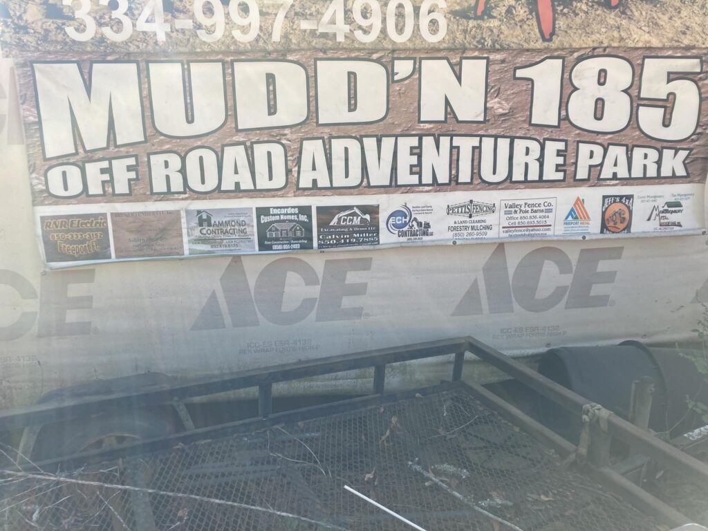 A sign for mudd ' n 1 8 off road adventure park
