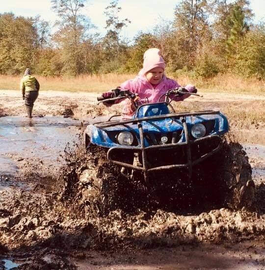A person on an atv in the mud.