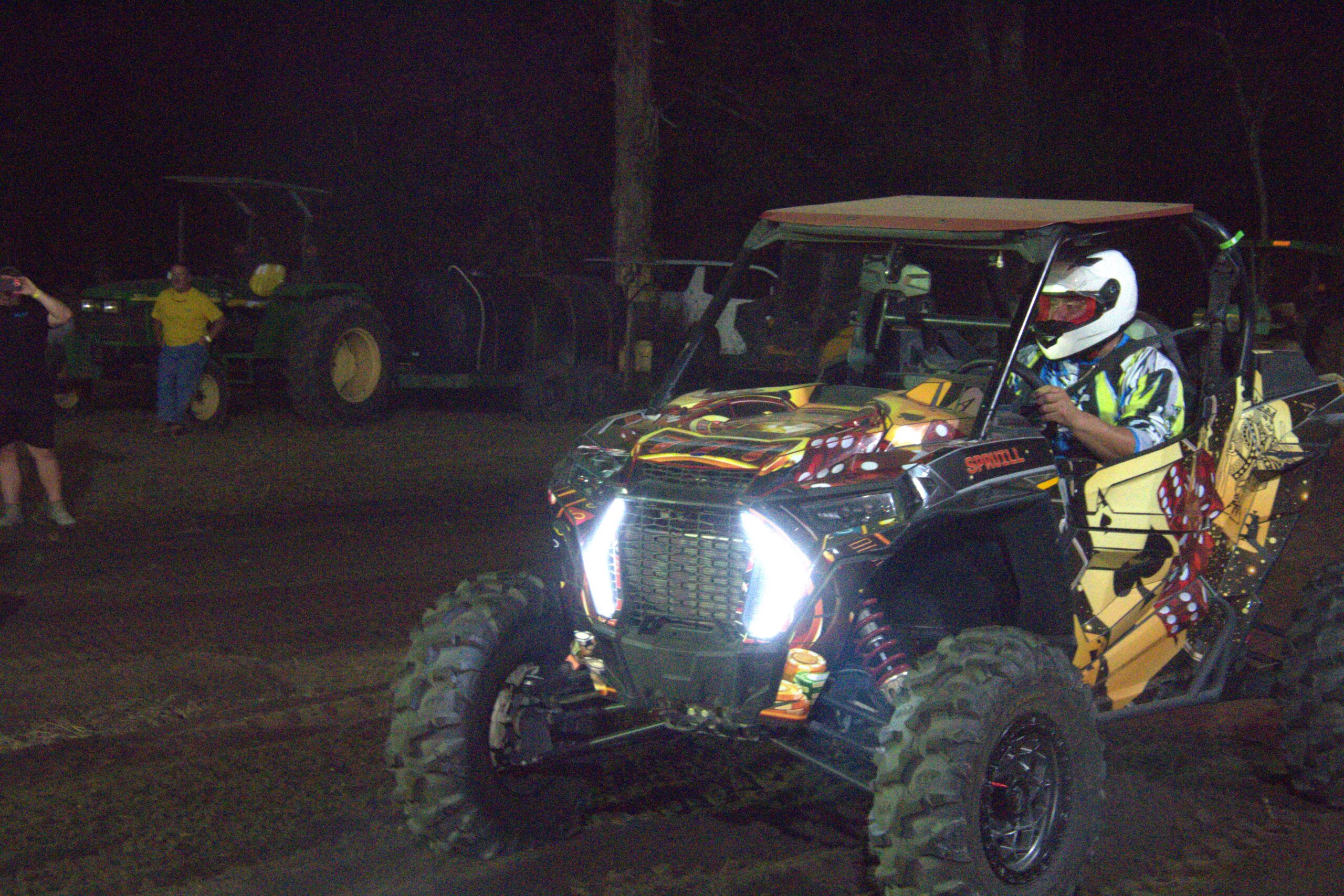 A man riding on the back of an atv at night.