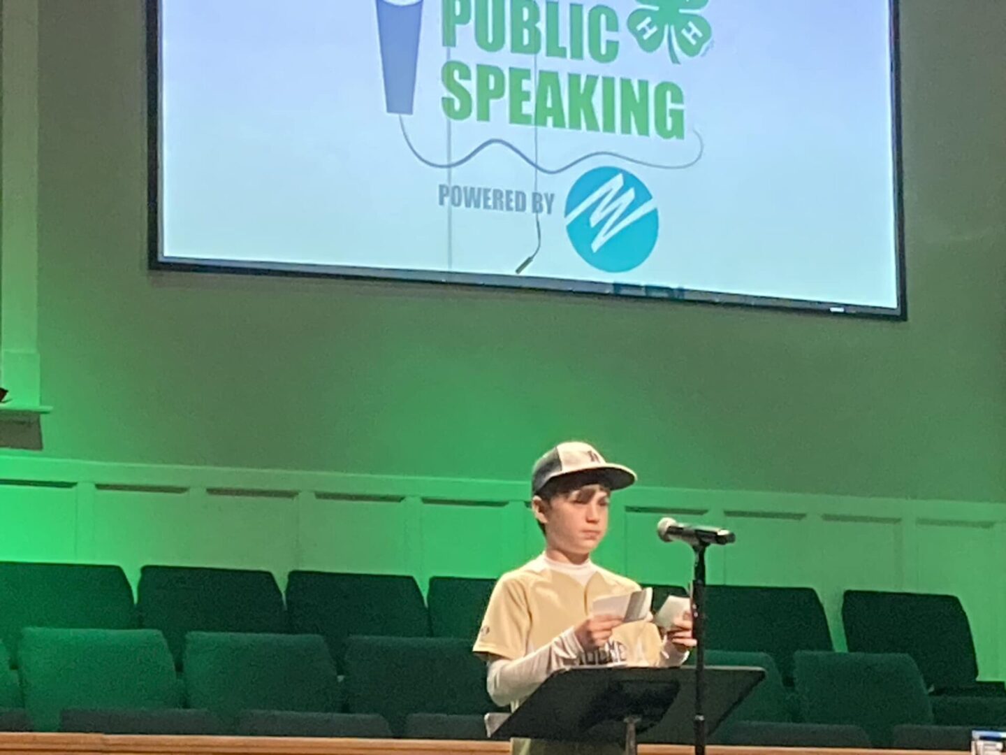Young speaker at microphone with presentation screen