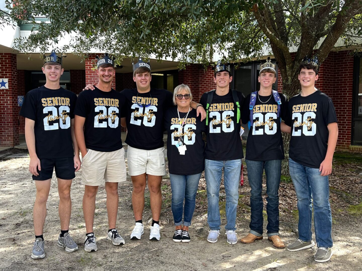 High school seniors posing outdoors in matching shirts