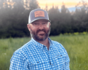 Smiling bearded man in baseball cap outdoors