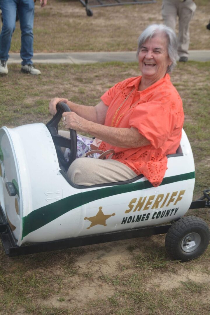 Smiling senior woman in mini sheriff car Smiling senior woman in mini sheriff car