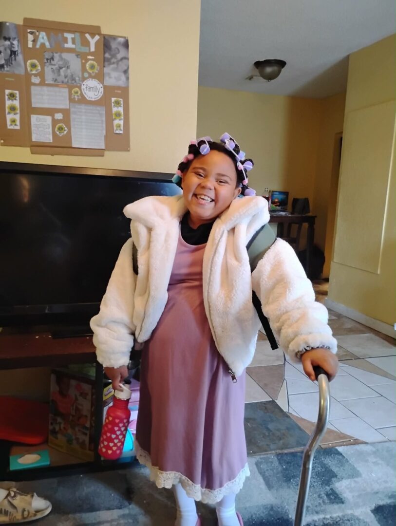 Smiling person in dress and jacket holding walker Smiling person in dress and jacket holding walker