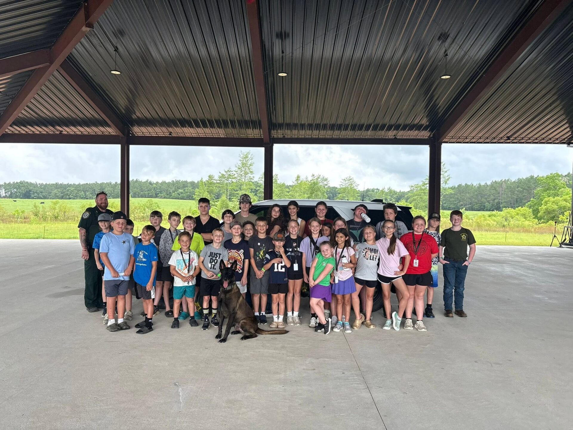 Large youth group posing with police dog